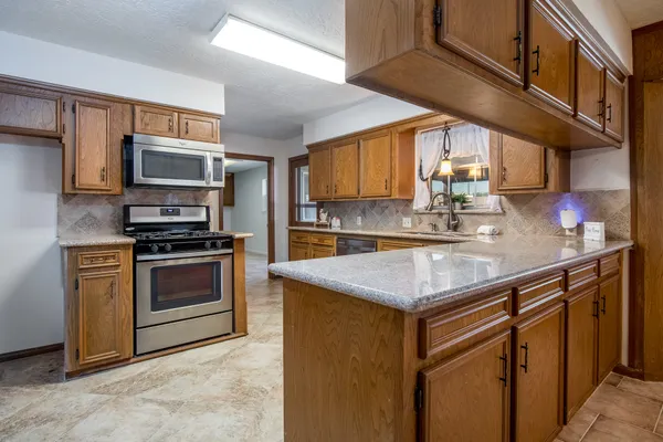 a kitchen with stainless steel appliances granite countertop a sink stove and microwave
