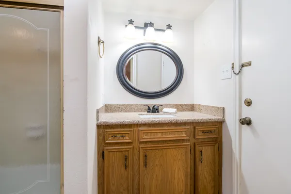 a bathroom with a granite countertop sink a mirror and a toilet