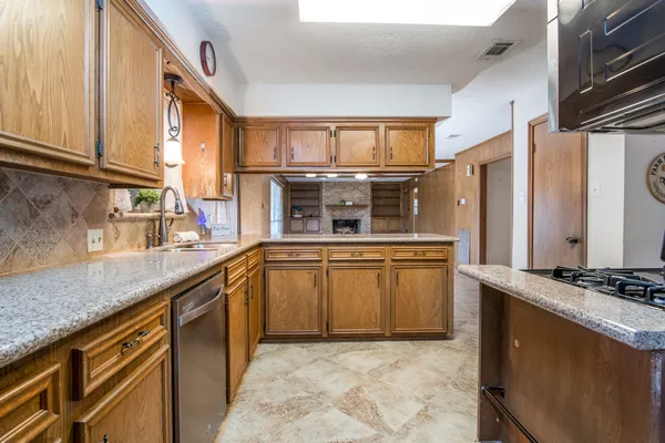 a kitchen with stainless steel appliances granite countertop a stove a sink and a microwave