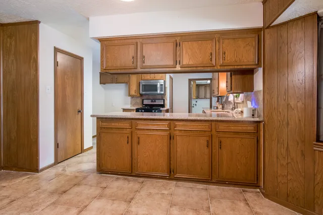 a kitchen with stainless steel appliances granite countertop a refrigerator and cabinets