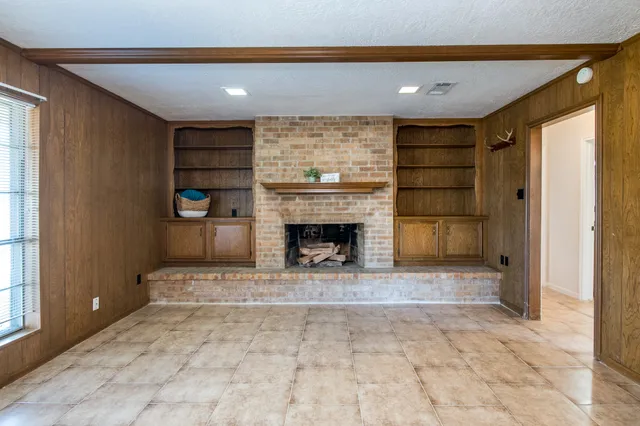 a view of a livingroom with a fireplace and window
