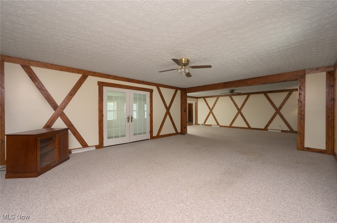 6600 Peck Road Ravenna, OH 44266 - Photo 20 of 50 Empty room featuring french doors, light carpet, a textured ceiling, and ceiling fan