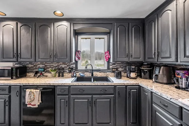 a kitchen with stainless steel appliances granite countertop a sink a stove and cabinets