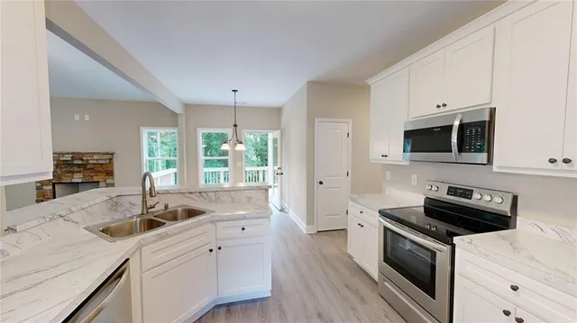 a view of an empty room with wooden floor fireplace and a window