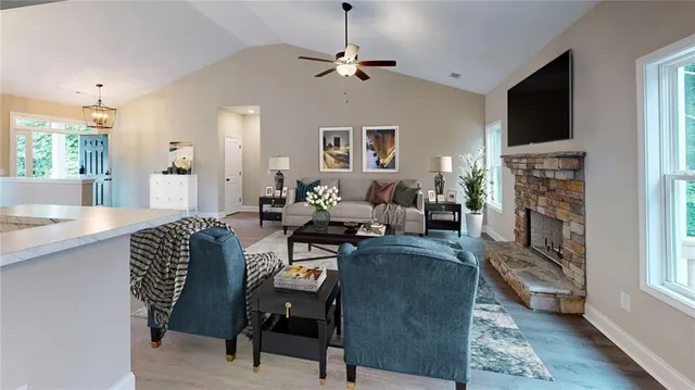 a view of an empty room and kitchen with wooden floor