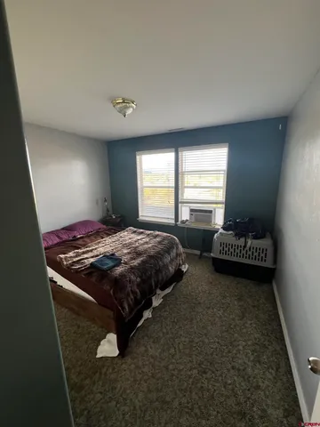 a bedroom with bed cabinet and window