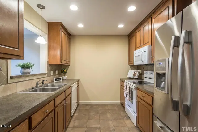 a kitchen with stainless steel appliances granite countertop a stove a sink and a refrigerator