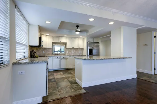 a large kitchen with stainless steel appliances granite countertop a stove a sink and a refrigerator