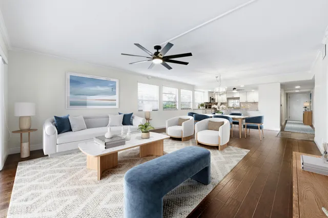 a living room with furniture kitchen view and a large window