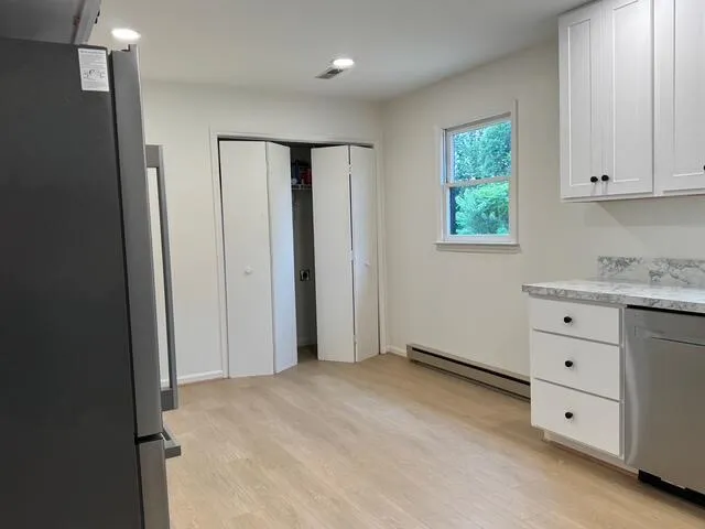 a view of an empty room with window and cabinet