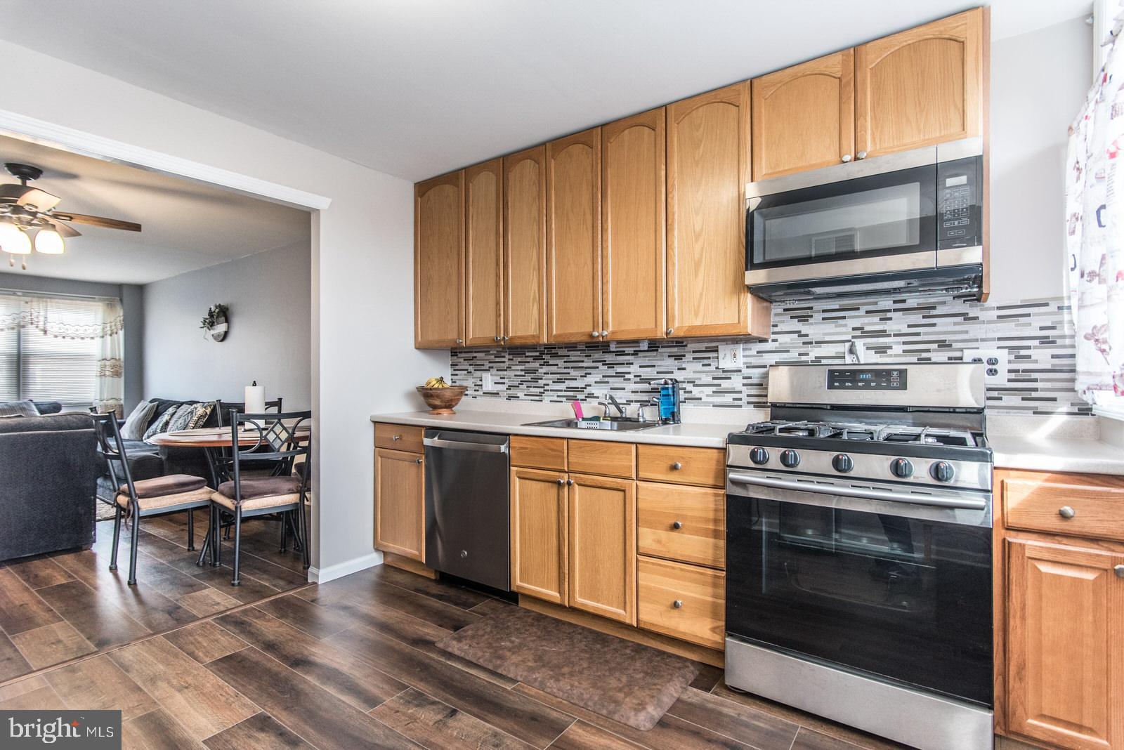 12138 Barbary Road Philadelphia, PA 19154 - Photo 20 of 71 a kitchen with stainless steel appliances a stove a sink cabinets and a microwave