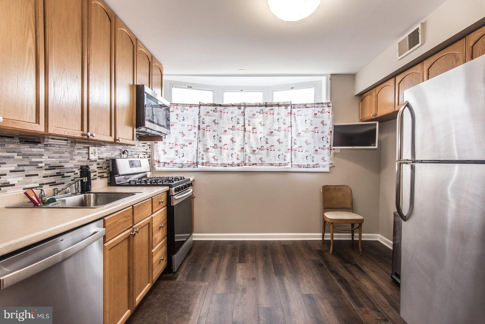 12138 Barbary Road Philadelphia, PA 19154 - Photo 22 of 71 a kitchen with stainless steel appliances granite countertop a refrigerator a sink dishwasher a stove and white countertops with wooden floor