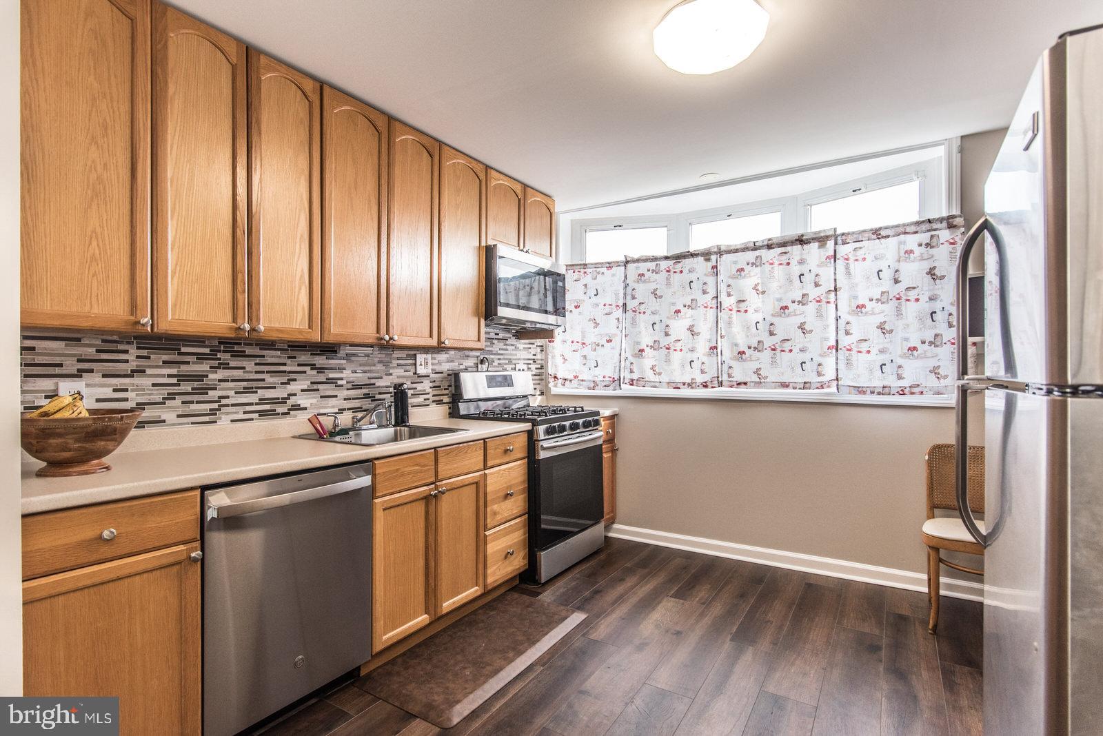 12138 Barbary Road Philadelphia, PA 19154 - Photo 23 of 71 a kitchen with stainless steel appliances granite countertop a refrigerator a sink dishwasher and wooden cabinets with wooden floor