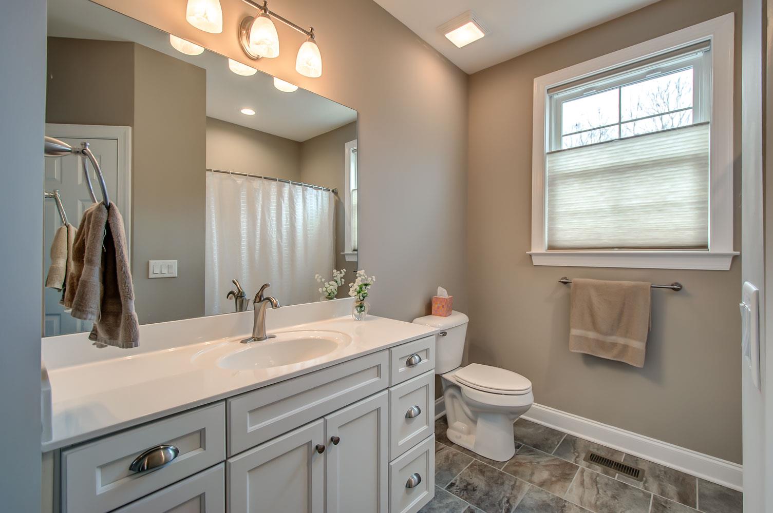 5705 Hopewell Ridge Road Franklin, TN 37064 - Photo 18 of 30 a bathroom with a toilet a sink a mirror a window and vanity