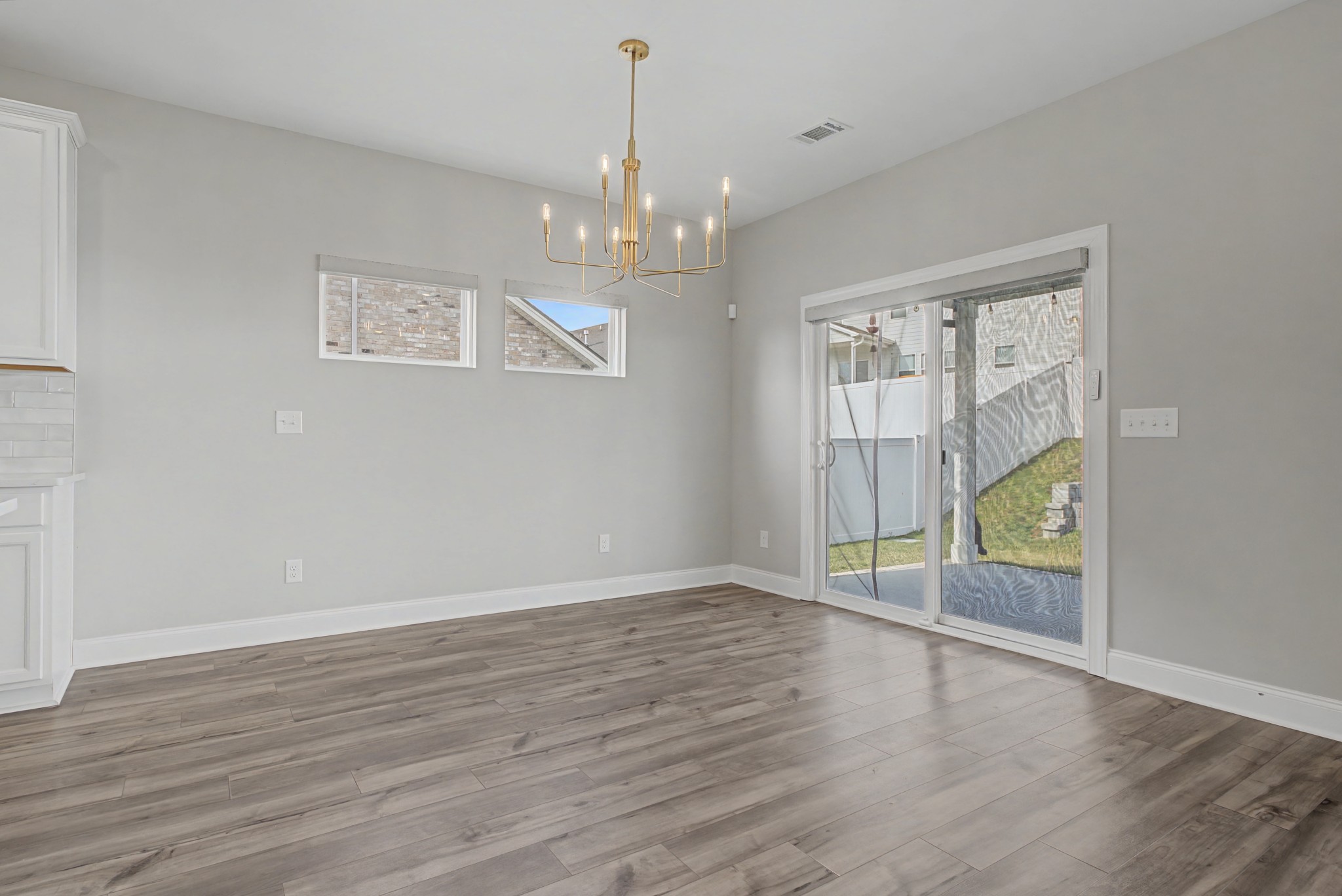 1205 Bridgett Way Mount Juliet, TN 37122 - Photo 15 of 43 an empty room with wooden floor chandelier and windows