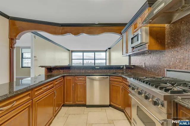 a kitchen with stainless steel appliances granite countertop a stove and a sink