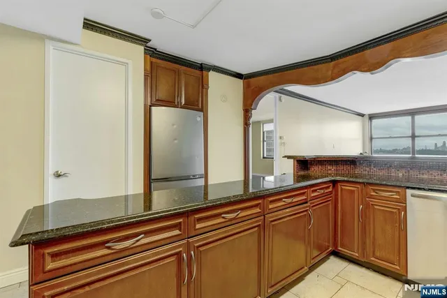 a kitchen with stainless steel appliances granite countertop a refrigerator and a sink