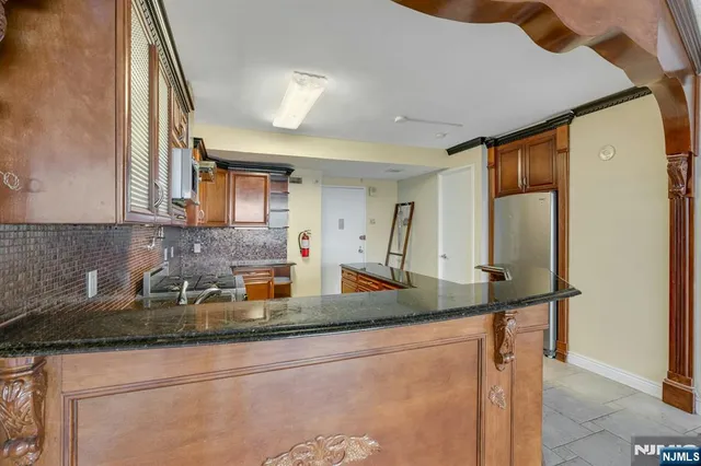 a kitchen with sink a refrigerator and a granite counter top