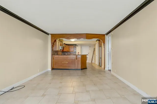 a view of a kitchen with a sink and dishwasher a refrigerator with white cabinets