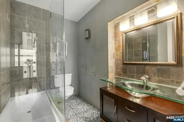 a bathroom with a granite countertop sink a mirror and a shower