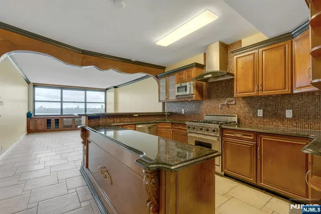 a kitchen with stainless steel appliances granite countertop a sink stove and cabinets