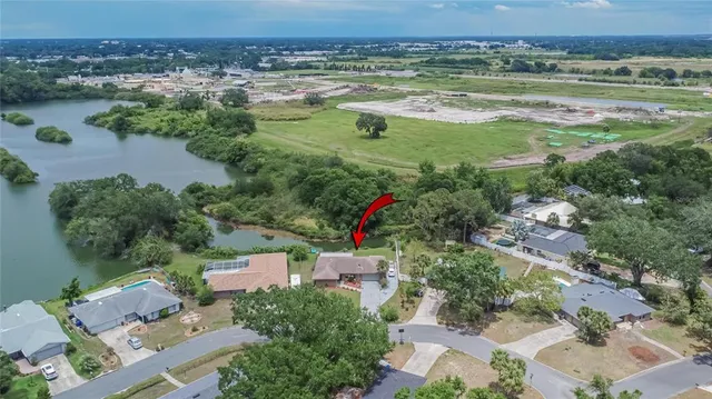 an aerial view of a house with a yard and lake view