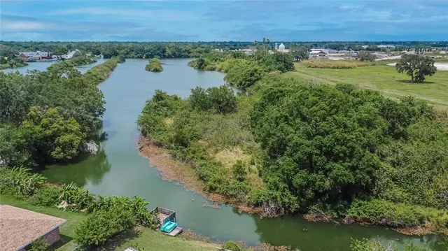 an aerial view of residential houses with outdoor space and trees all around
