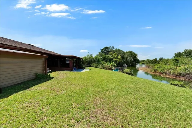 a kitchen with granite countertop a stove a sink and white cabinets