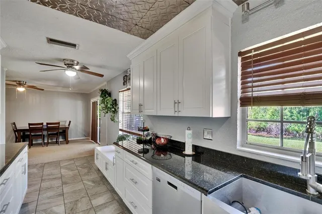 a large white kitchen with stainless steel appliances granite countertop lots of counter top and sink