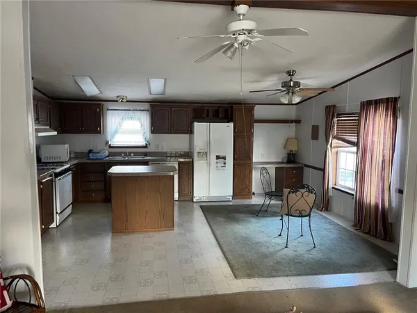 a view of kitchen with sink microwave and refrigerator