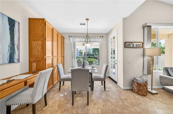 a dining room with furniture and large windows