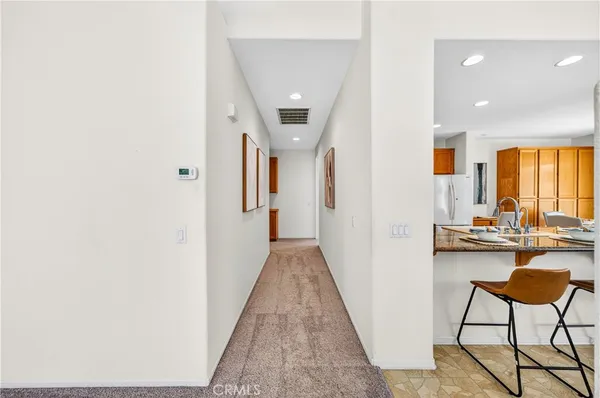 a view of a hallway with furniture and a window