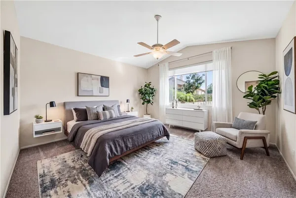 a bedroom with a bed a chandelier and a couch