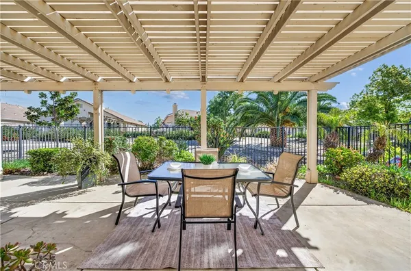 a patio with table and chairs and potted plants