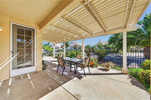 a view of a patio with a table and chairs under an umbrella