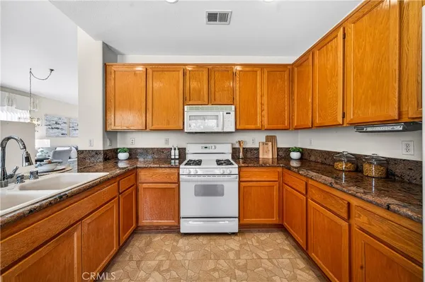 a kitchen with stainless steel appliances granite countertop wooden cabinets sink and a granite counter top