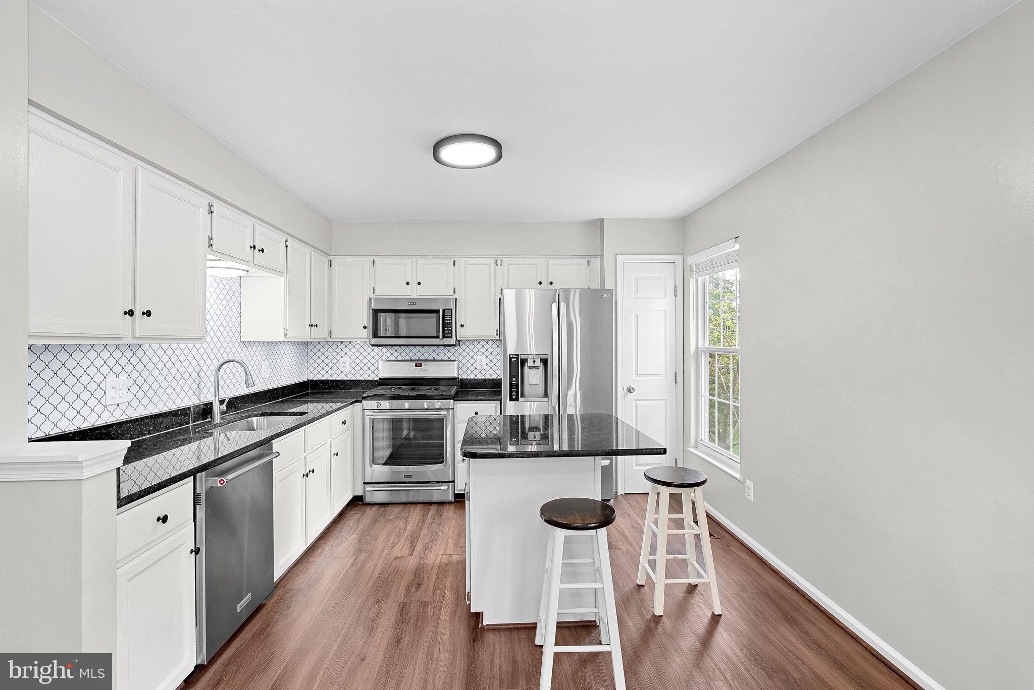 21074 Cornerpost Square Ashburn, VA 20147 - Photo 12 of 81 a kitchen with stainless steel appliances granite countertop a stove a sink dishwasher and a refrigerator with wooden floor