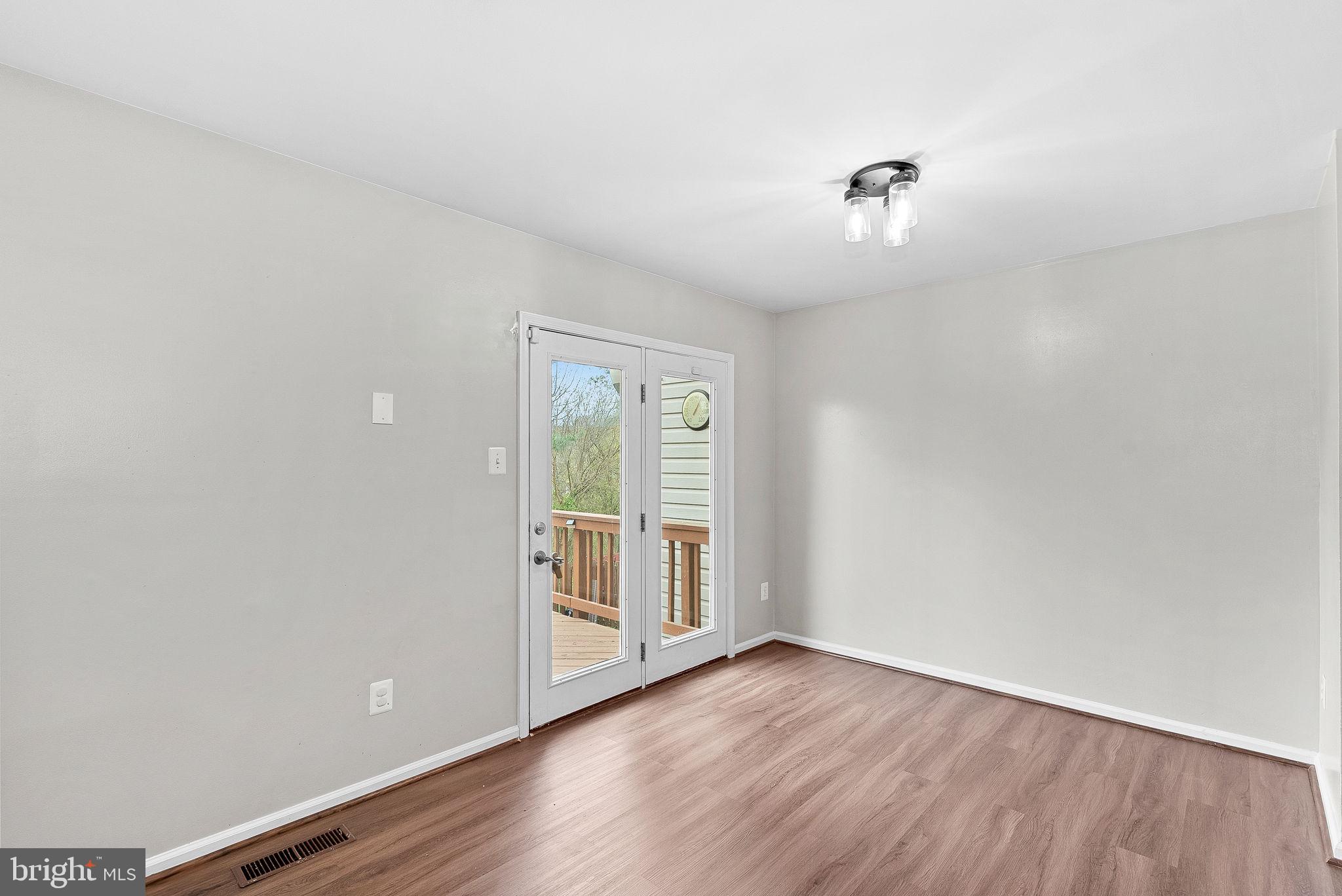 21074 Cornerpost Square Ashburn, VA 20147 - Photo 19 of 81 an empty room with wooden floor and natural light