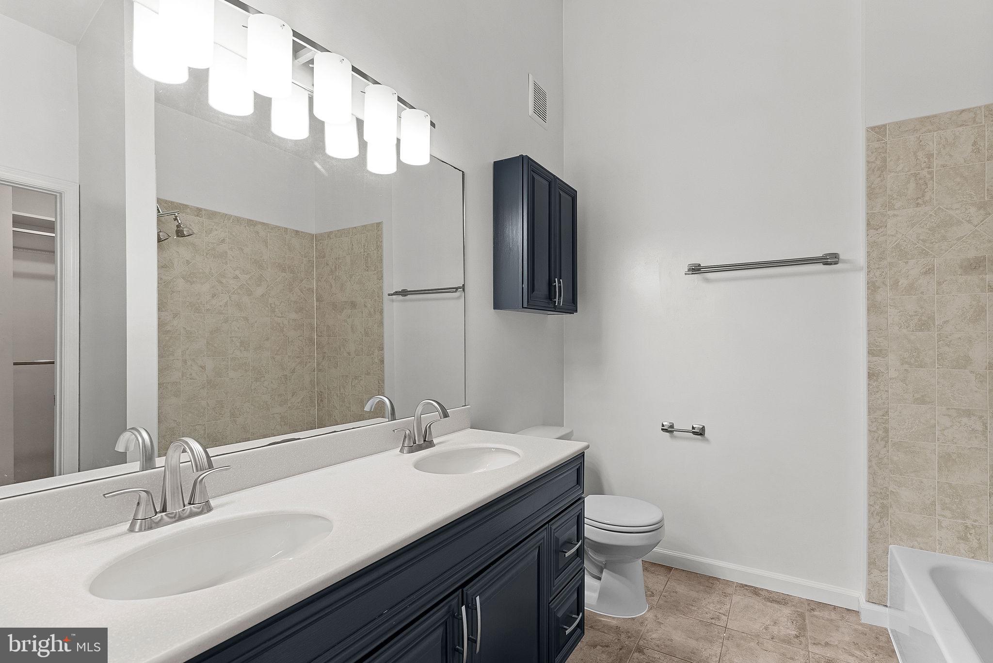 21074 Cornerpost Square Ashburn, VA 20147 - Photo 27 of 81 a bathroom with a double vanity sink and a mirror