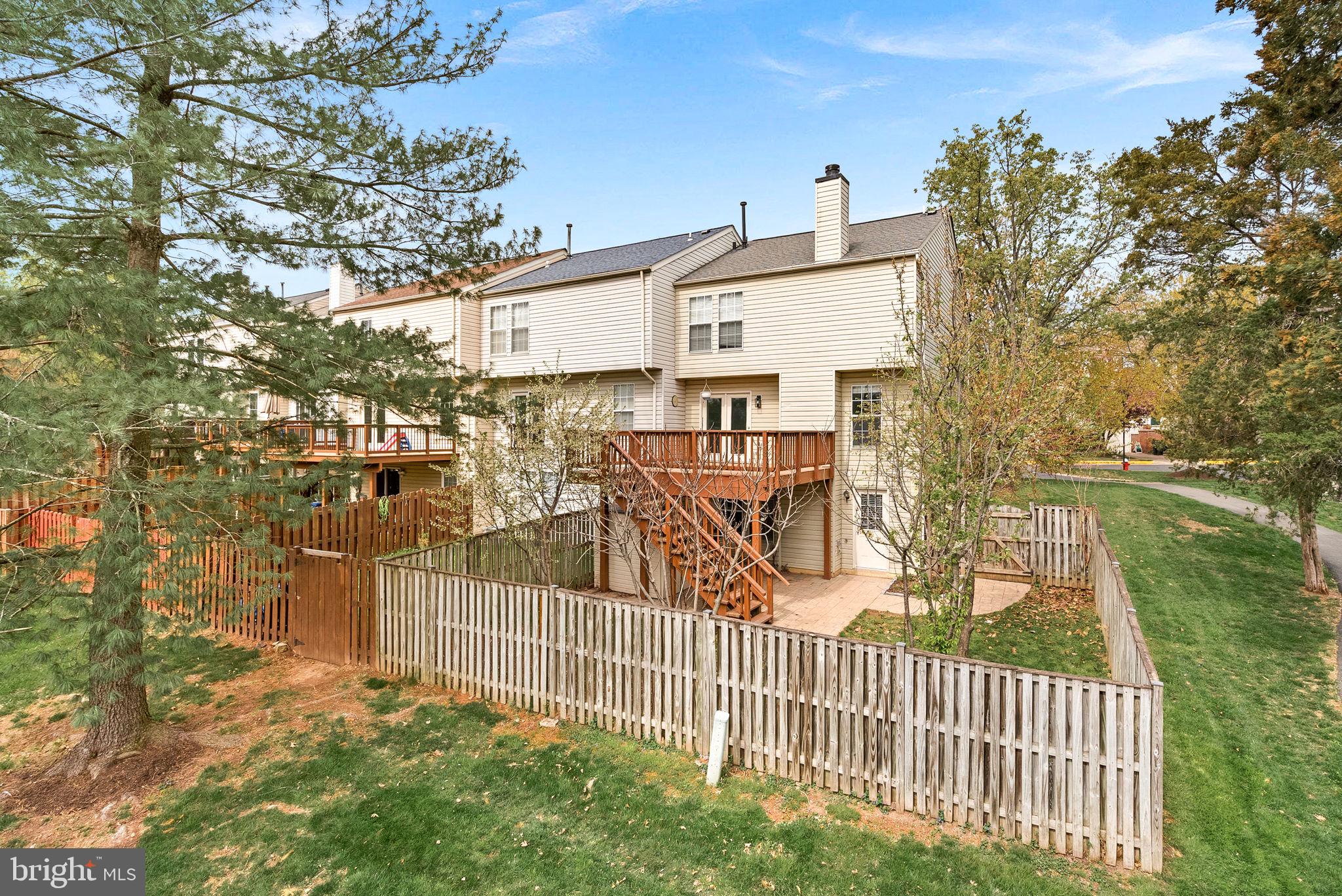 21074 Cornerpost Square Ashburn, VA 20147 - Photo 60 of 81 a view of a house with a small yard and wooden fence
