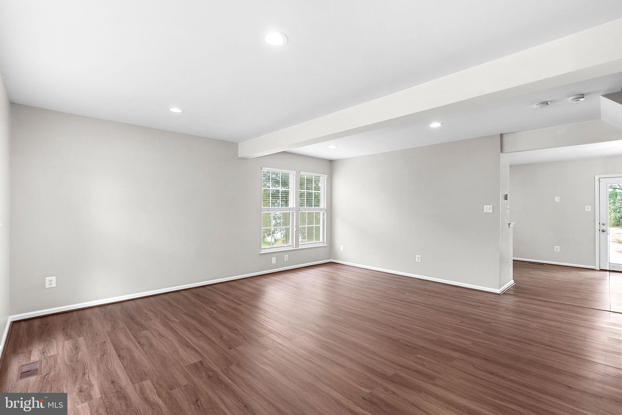 21074 Cornerpost Square Ashburn, VA 20147 - Photo 6 of 81 a view of an empty room with wooden floor and a window