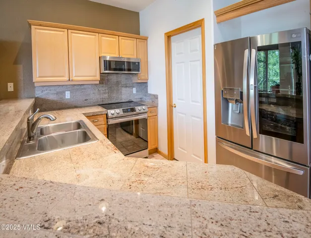 a kitchen with granite countertop a refrigerator and a sink