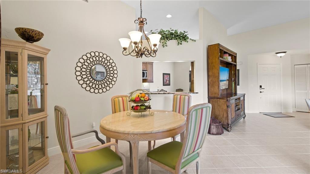 577 Beachwalk Circle, Unit R202 Naples, FL 34108 - Photo 15 of 44 Dining space featuring a chandelier and light tile patterned floors
