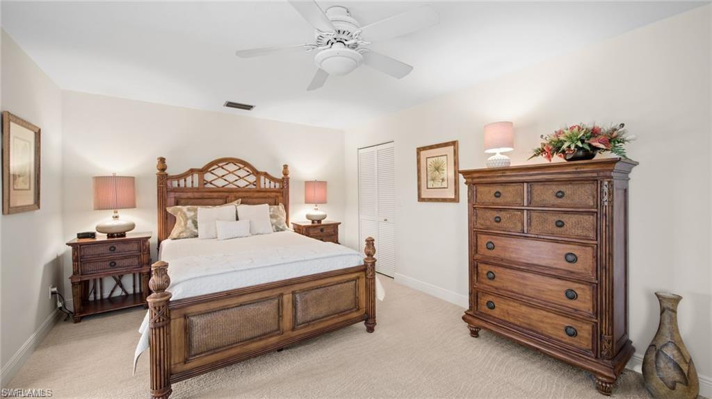 577 Beachwalk Circle, Unit R202 Naples, FL 34108 - Photo 20 of 44 Bedroom featuring a closet, light colored carpet, and a ceiling fan