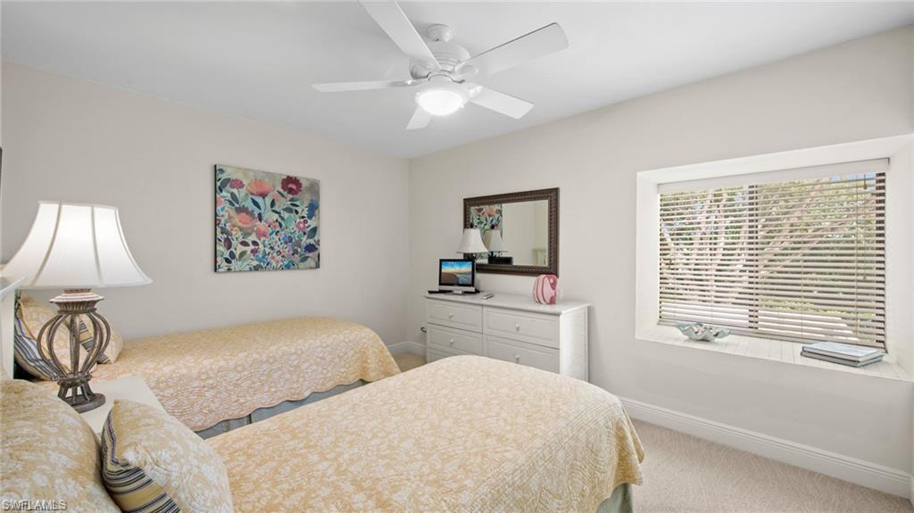 577 Beachwalk Circle, Unit R202 Naples, FL 34108 - Photo 22 of 44 Bedroom with light colored carpet and ceiling fan