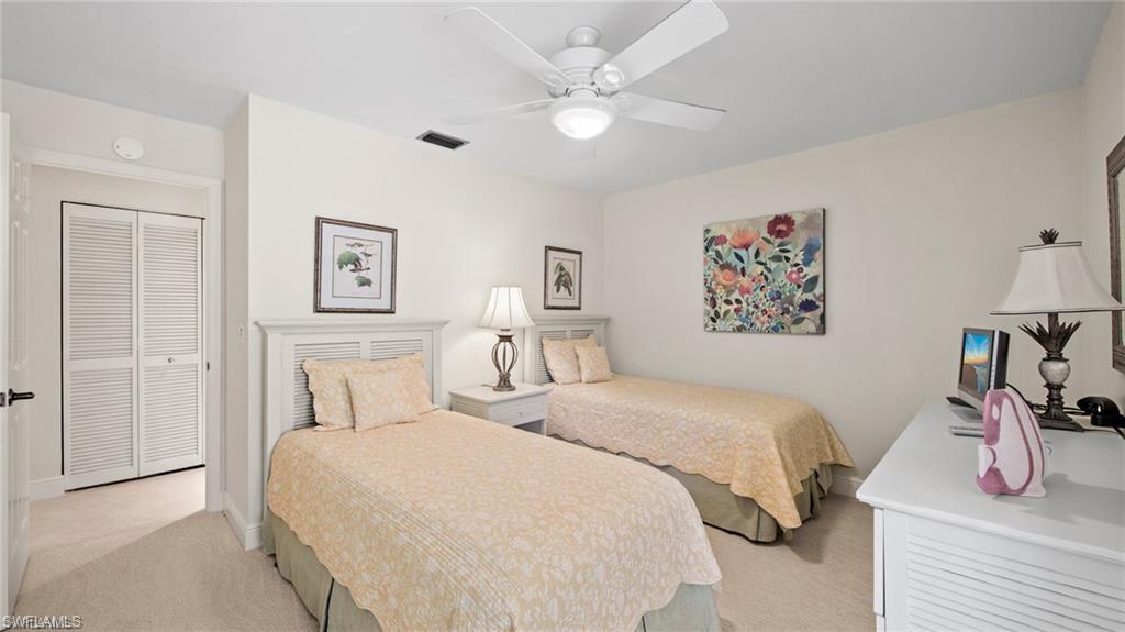 577 Beachwalk Circle, Unit R202 Naples, FL 34108 - Photo 23 of 44 Bedroom with light carpet, ceiling fan, and a closet