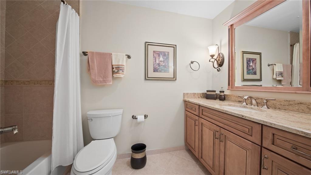 577 Beachwalk Circle, Unit R202 Naples, FL 34108 - Photo 24 of 44 Bathroom with vanity, light tile patterned flooring, and shower / bathtub combination with curtain
