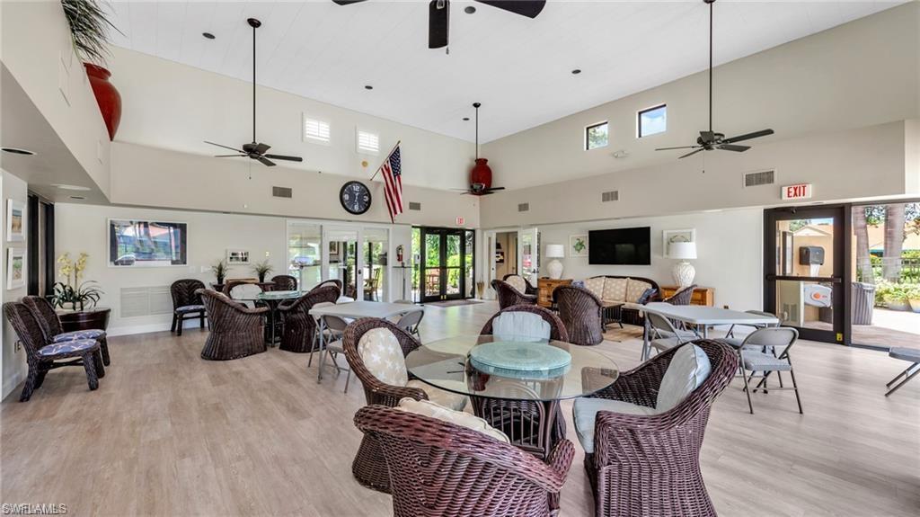 577 Beachwalk Circle, Unit R202 Naples, FL 34108 - Photo 35 of 44 Dining room featuring a high ceiling, light wood-style floors, a ceiling fan, and french doors