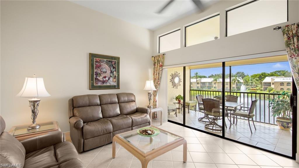 577 Beachwalk Circle, Unit R202 Naples, FL 34108 - Photo 6 of 44 Tiled living room featuring plenty of natural light, a high ceiling, and a ceiling fan
