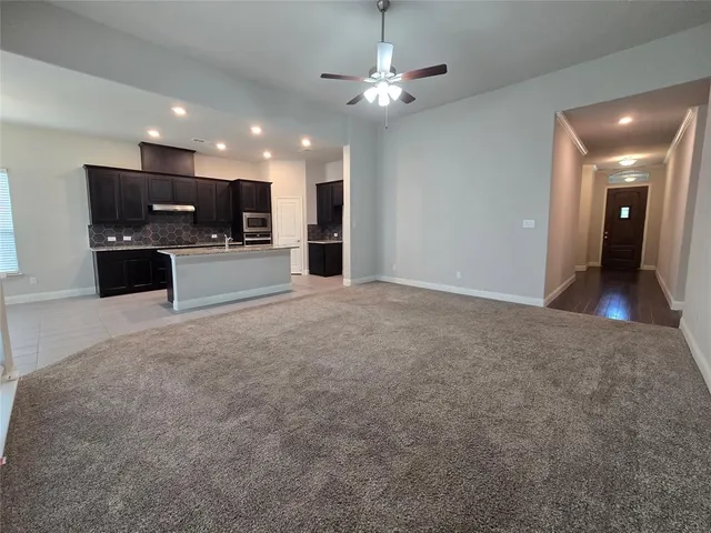 a view of an empty room with a kitchen